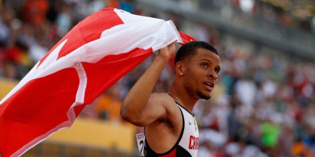 TORONTO, ON - JULY 24: Andre De Grasse of Canada holds the Canadian flag after winning the men's 200...