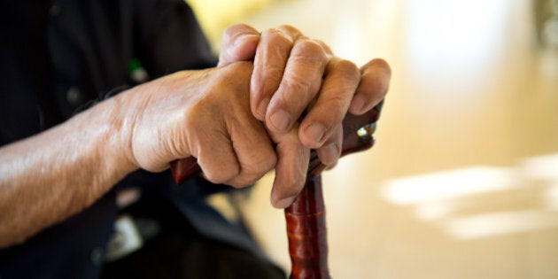 old man sitting with his hands...