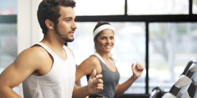 Cheerful smiling and beautiful people running at the fitness club.