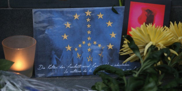 BERLIN, GERMANY - MARCH 22: A peace sign combined with the flag of the European Union lies among flowers and a candle at the steps of the Belgian Embassy following today's terrorist attacks in Brussels on March 22, 2016 in Berlin, Germany. The Islamic State has claimed responsibility for the attack in which terrorists detonated three explosives devices at Brussels airport and in a metro train and killed at least 30 people. (Photo by Sean Gallup/Getty Images)