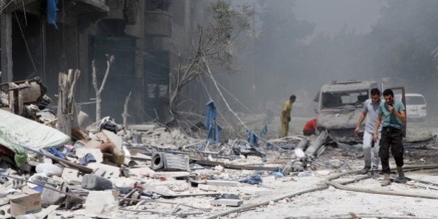 ALEPPO, SYRIA - AUGUST 27: Syrian people try to rescue people from the wreckage of collapsed buildings after the airstrike belonging to Syrian army targeted at opposition controlled in Bab al-Nairab district in Aleppo, Syria on August 27, 2016. It is reported that many people killed and wounded after the airstrike. (Photo by Ibrahim Ebu Leys/Anadolu Agency/Getty Images)