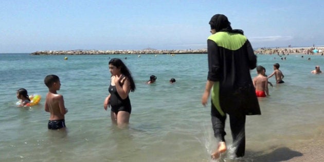 FILE - In this Aug. 4 2016 file photo made from video, Nissrine Samali, 20, gets into the sea wearing a burkini, a wetsuit-like garment that also covers the head, in Marseille, southern France. France's top administrative court has overturned Friday Aug. 26, 2016 a town burkini ban amid shock and anger worldwide after some Muslim women were ordered to remove body-concealing garments on French Riviera beaches. (AP Photo, File)