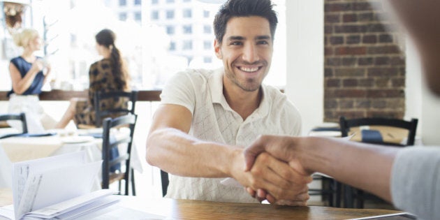 Businessmen shaking hands in cafe