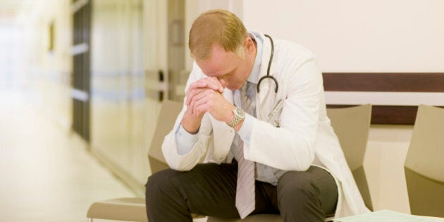 Frustrated doctor sitting in hospital waiting area