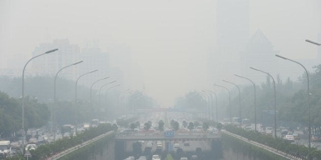 This picture taken on June 23, 2015 shows vehicles running in smog covered streets in Beijing. China's cities are often hit by heavy pollution, blamed on coal-burning by power stations and industry, as well as vehicle use. The issue has become a major source of popular discontent with the Communist Party, leading the government to vow to reduce the proportion of energy derived from fossil fuels. CHINA OUT AFP PHOTO (Photo credit should read STR/AFP/Getty Images)