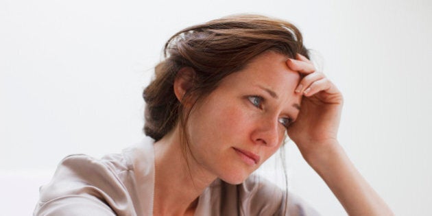 Depressed woman with head in hands