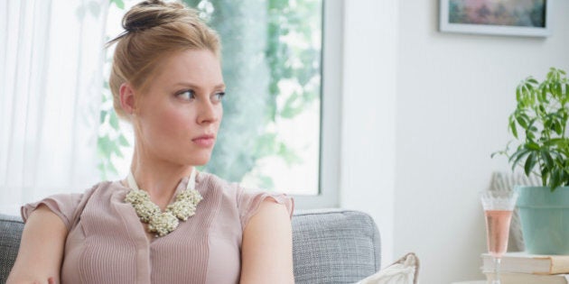 USA, New Jersey, Jersey City, Upset young woman sitting on sofa