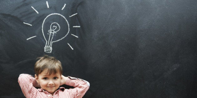 Studio shot of a young boy with a chalk drawing of a light bulb above his head