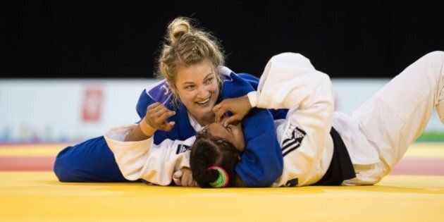 Kelita Zupancic (Top) of Canada smiles as she pins Onix Cortes of Cuba to win the gold medal in the women's judo 70kg class at the 2015 Pan American Games in Toronto, Canada on July 13, 2015. AFP PHOTO/GEOFF ROBINS (Photo credit should read GEOFF ROBINS/AFP/Getty Images)
