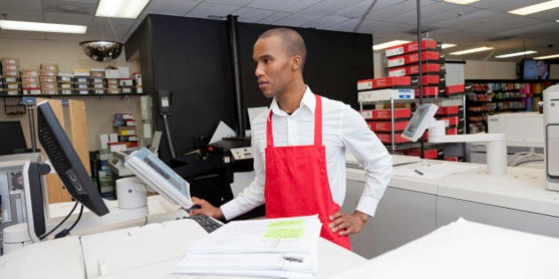 Manual worker looking at cash register machine