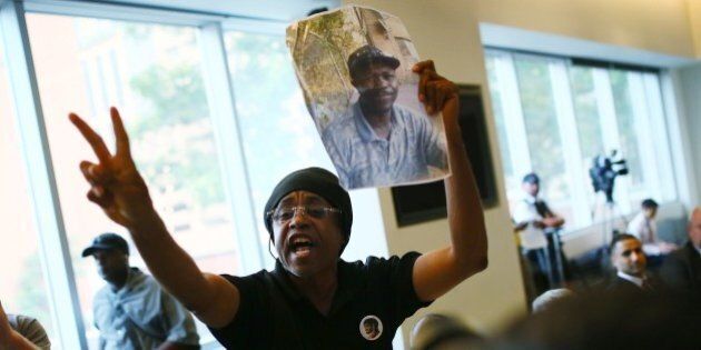TORONTO, ON - SEPTEMBER 1: Cecil Peter holds up a photo of Andrew Loku, who last month was shot by police and later died of his injuries, at a carding consultation meeting at the Toronto Reference Library. (Cole Burston/Toronto Star via Getty Images)