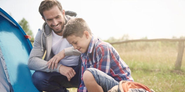 Father teaching son how to pitch a tent