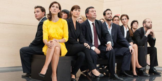 Businesspeople sitting on crowded bench