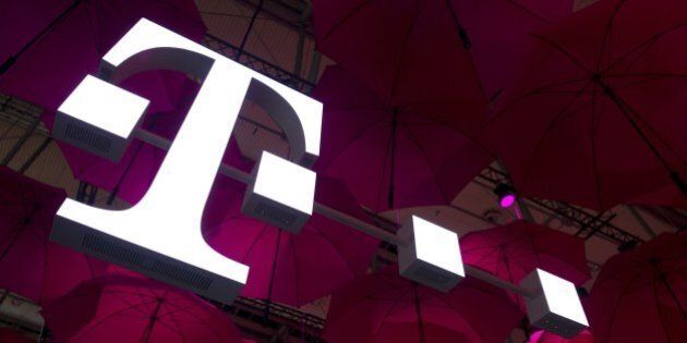 A Deutsche Telekom T-Mobile logo hangs under pink umbrellas at the stand of the German telecommunications giant at the 2014 CeBIT computer technology trade fair on March 10, 2014 in Hanover, central Germany. Great Britain is partner country of the fair considered as the world's biggest high-tech fair running from March 10 to 14, 2014. AFP PHOTO / JOHN MACDOUGALL (Photo credit should read JOHN MACDOUGALL/AFP/Getty Images)