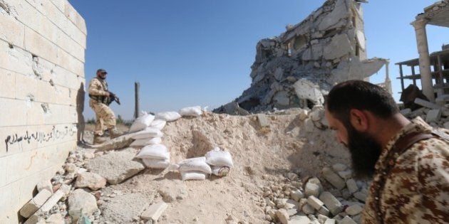 Rebel fighters walk on the rubble of destroyed buildings at a former research centre being used as a military barracks after they captured the complex, on July 4, 2015, on the western outskirts of the Syrian city of Aleppo. Two coalitions of Syrian rebels battled to advance in government-held western Aleppo, seizing the army barracks in one district but being pushed back in others. AFP PHOTO / ALEPPO MEDIA CENTRE / ZEIN AL-RIFAI (Photo credit should read ZEIN AL-RIFAI/AFP/Getty Images)