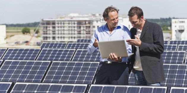 Germany, Munich, Engineer and man discussing in solar plant