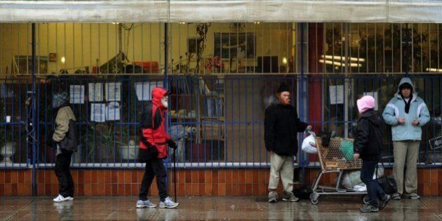 A group of homeless and poor seek shelter from the rain outside a store in the Downtown Eastside area of Vancouver on February 11, 2010. Canada is spending over two billion dollars on the Winter Olympics but just steps away from the venue for the opening ceremony sits one of the country's most notorious slums where drug addiction and prostitution are rife. The scenes of homelessness and the squalor of Downtown Eastside are not the images Olympic organizers want visitors to leave with. But the neighbourhood's close proximity to BC Place Stadium where the Olympic cauldron will be lit on Feb.12, will make it hard for visitors to miss. AFP PHOTO/Mark RALSTON (Photo credit should read MARK RALSTON/AFP/Getty Images)