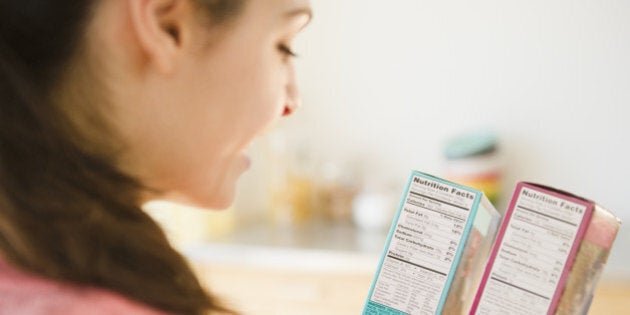 Woman reading nutrition facts on food packaging