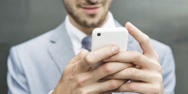 close up of businessman holding mobile phone.