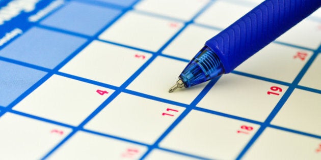 Close-up of an office calendar and a pen.