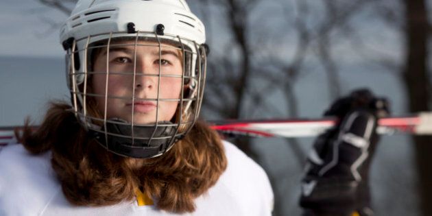 Eleven year old girl hockey player portrait on an ice rink overlooking Lake Michigan in Wisconsin.