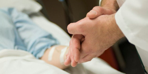 Doctor holding patient's hand, cropped