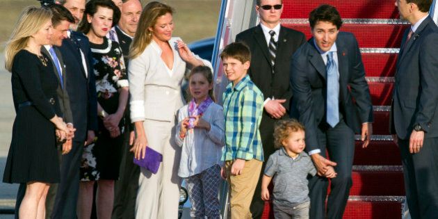 Canadian Prime Minister Justin Trudeau, right, his wife Sophie Grgoire-Trudeau, center left, and their children walk down a red carpet after arriving at Andrews Air Force Base, Md., Wednesday, March 9, 2016. (AP Photo/Cliff Owen)