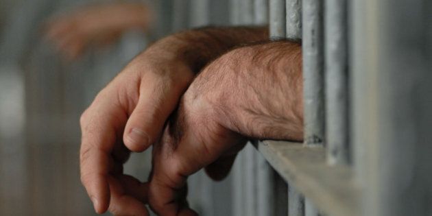 man behind bars or in jail