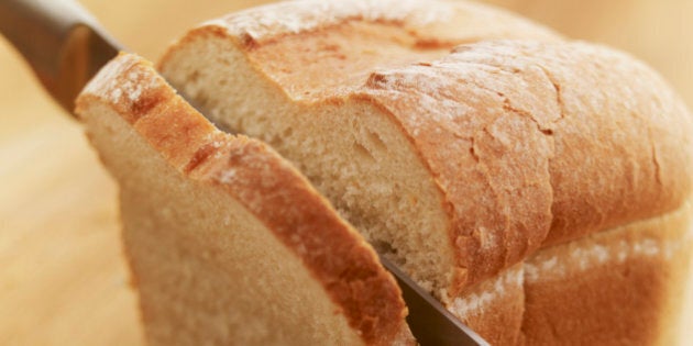 Knife slicing loaf of bread