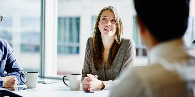 Businesswoman leading project discussion during morning meeting in office