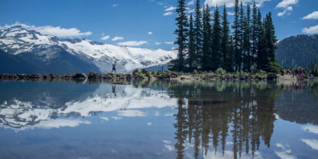 Reflections of trees and snow covered mountain on Garibaldi Lake