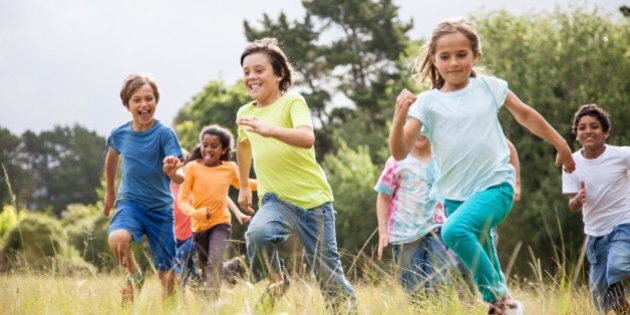 Children, aged 9-10, running together in a park