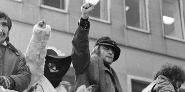 John Lennon and his wife Yoko Ono raise their fists as they join a protest, Feb. 5, 1972, by about 500 persons in front of British Overseas Airways Corp. offices in New York on Fifth Avenue. The demonstrators called for the withdrawal of British troops from Northern Ireland. (AP Photo/Ron Frehm)