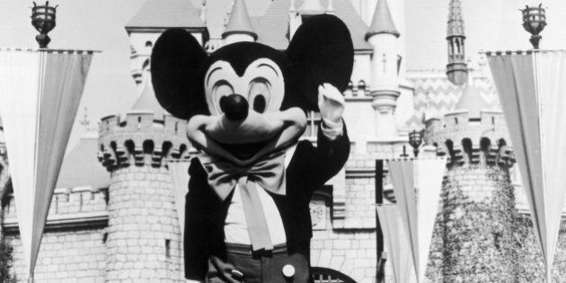 circa 1955: A person in a Mickey Mouse costume at the gate of the Magic Kingdom at the Disneyland theme park, Anaheim, California. (Photo by Hulton Archive/Getty Images)