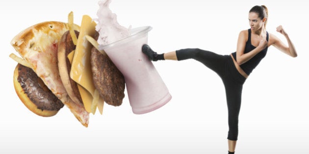 Fit young woman fighting off fast food