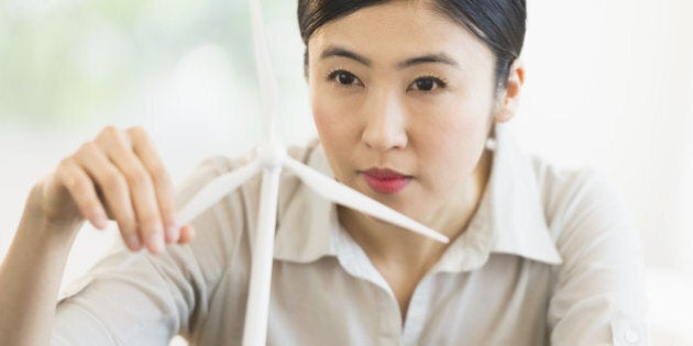 Female engineer working on model of wind turbine