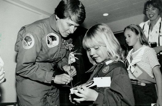 Fair exchange: Astronaut Dr. Roberta Bondar gives a NASA decal to Sara, a Brownie, who presented her