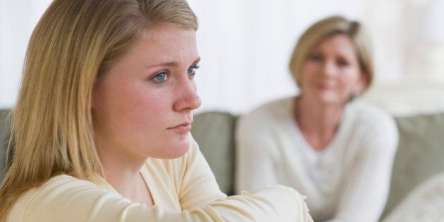 Teenaged girl looking away from mother