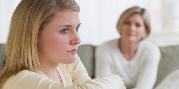 Teenaged girl looking away from mother