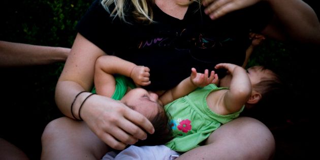 A mother breast-feeds her twin baby girls in Santa Barbara, California.