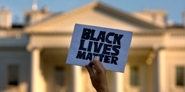 In this July 8, 2016, photo, a man holds up a sign saying