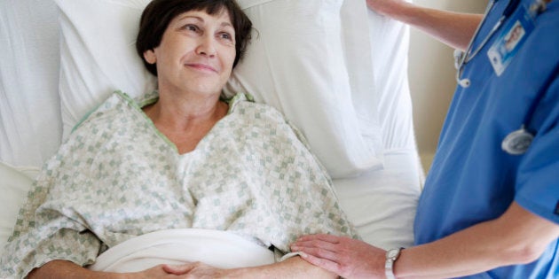 Nurse comforting senior female patient