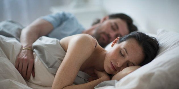 USA, New Jersey, Couple sleeping together in bed at night