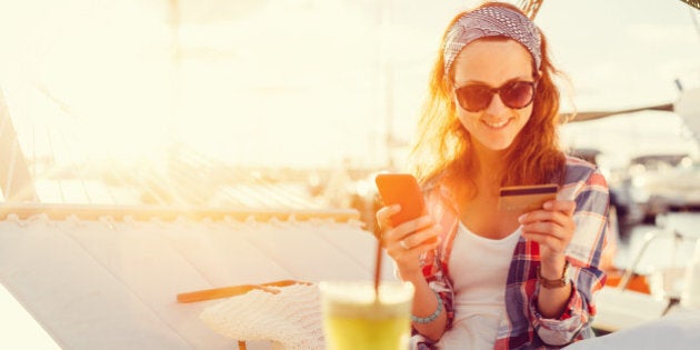 Woman in a hammock using credit card for online shopping +++++ Note for the inspector : Credit card is fake +++++