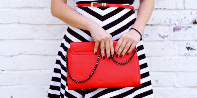 Outdoor Fashionable girl near white street wall .Marine and retro style. striped dress with red handbag clutch