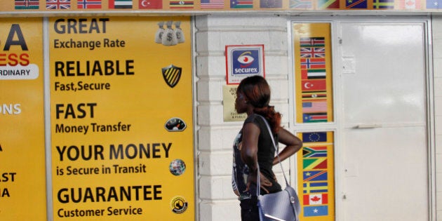 A woman looks at the closed doors of a money-transfer service in Nairobi, Kenya Wednesday, April 8, 2015. The Kenya government said Wednesday that it was freezing the accounts of a list of companies and individuals identified because of suspicious transactions, with the list including some money-transfer services dealing in remittances to Somalia. (AP Photo/Khalil Senosi)