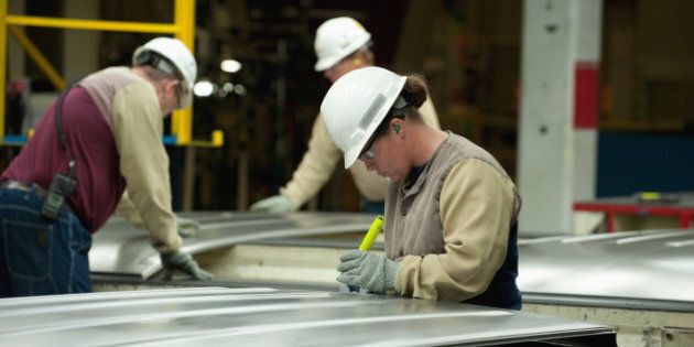 Before they are welded to assemble a mini-van body, workers inspect sheet metal components for flaws and distortions of shape.