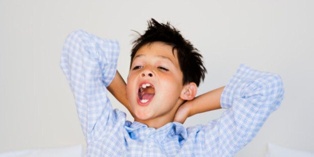 Little boy yawning and stretching