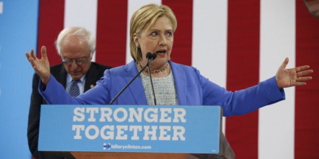 Sen. Bernie Sanders, I-Vt. listens as Democratic presidential candidate Hillary Clinton speaks during a rally in Portsmouth, N.H., Tuesday, July 12, 2016, where Sanders endorsed Clinton for president. (AP Photo/Andrew Harnik)