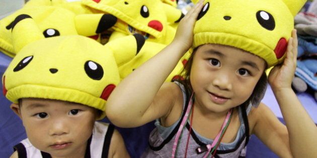Ami Kobayashi (R) and her younger brother Akio put on Pokemon caps during Pokemon Festa 2005 in Yokohama, south of Tokyo August 20, 2005. Over 900,000 people attended the largest Pokemon event in Japan in nine places during this summer.